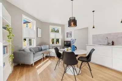 a living room with a couch and a table and chairs at Central 3-room apartment in Trondheim