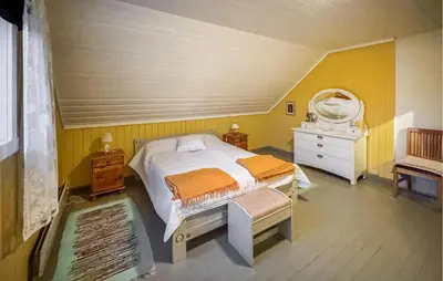 a bedroom with a bed and a dresser and a mirror at Nice Home In Braskereidfoss With Wifi in Braskereidfoss