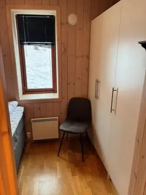 a small room with a chair and a window at Ski-in & ski-out apartment in Hafjell in Øyer