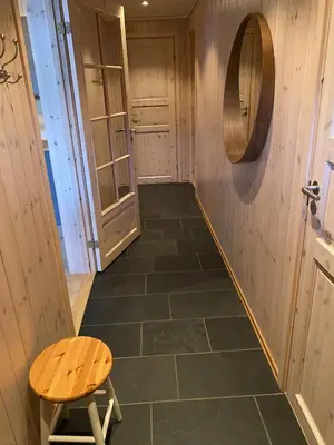 a hallway with a wooden floor and a stool at Ski-in & ski-out apartment in Hafjell in Øyer