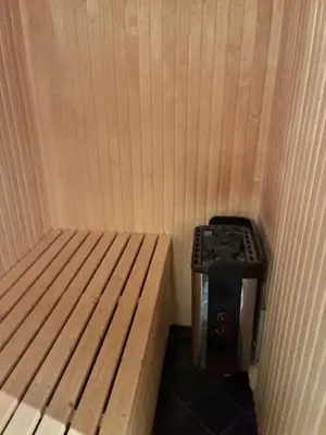 a small room with a bed and a stove at Ski-in & ski-out apartment in Hafjell in Øyer