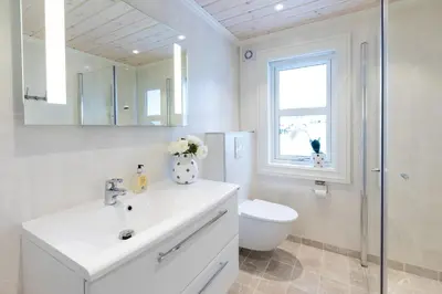a bathroom with a sink and a toilet and a mirror at Stranda Fjellgrend 3 bedrooms - 98B in Stranda