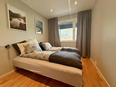 a bed sitting in a room with a window at Central apartment - walking distance to everything in Holo