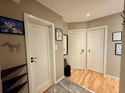 a hallway with two white doors and wood floors at Central apartment - walking distance to everything in Holo
