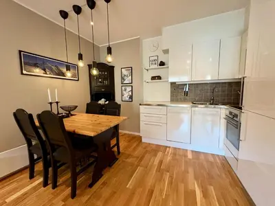 a kitchen and dining room with a wooden table and chairs at Central apartment - walking distance to everything in Holo