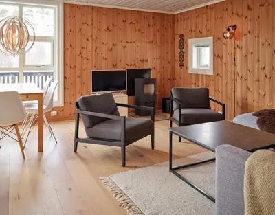 a living room with a table and chairs and a tv at Stranda Fjellgrend 2 bedrooms - 76B in Stranda