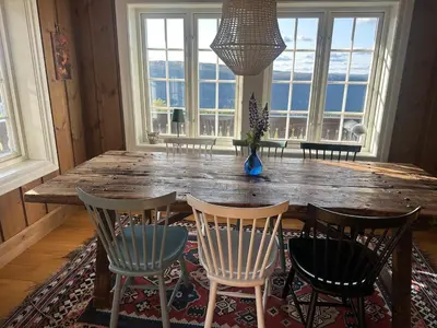 a dining room with a wooden table and chairs at Rustik hytte i Gausta, ski in, ski out, 10 beds in Gaustablikk