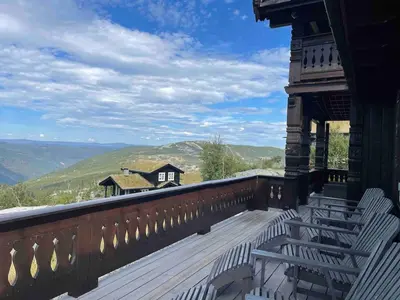 a balcony with chairs and a view of the mountains at Rustik hytte i Gausta, ski in, ski out, 10 beds in Gaustablikk