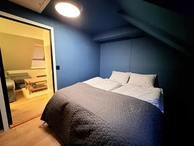 a bedroom with a bed with a blue wall at Cozy Apartment Next to Solsiden in Trondheim