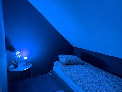 a blue room with a bed and a side table at Cozy Apartment Next to Solsiden in Trondheim