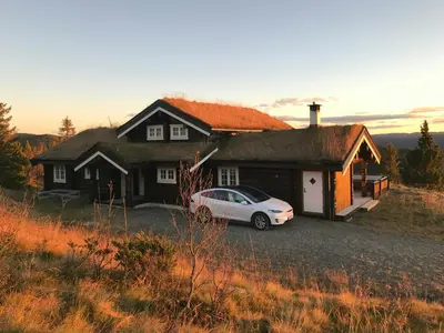 a white car parked in front of a house at Family Cabin With Panoramic Views In Aurdalsåsen in Aurdal