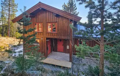 a cabin in the woods with a wooden deck at Stunning Home In Austbygda With Wifi in Austbygdi