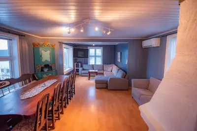 a living room with a couch and a table and chairs at Sentralen in Trysil