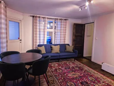 a living room with a blue couch and a table at Cozy 2BD apartment in Central Bergen in Bergen