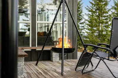 a fire pit on a deck with a chair at Mountain Cabin With Ski Inout In Trysil in Trysil