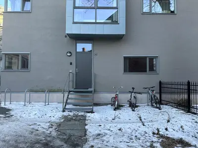 two bikes parked in front of a building with a door at Midtbyen Apartment in Trondheim