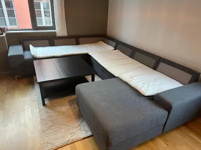 a room with two beds and a table and a couch at Midtbyen Apartment in Trondheim