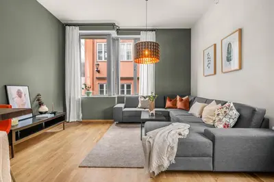 a living room with a gray couch and a window at Midtbyen Apartment in Trondheim