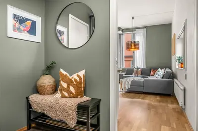 a living room with a mirror and a couch at Midtbyen Apartment in Trondheim