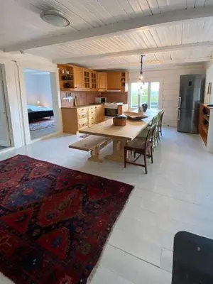 a large kitchen with a wooden table and chairs at Historic Timber Cabin With Views Of Rondane in Furuhovde