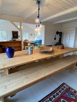 a large wooden table in a living room with a table at Historic Timber Cabin With Views Of Rondane in Furuhovde