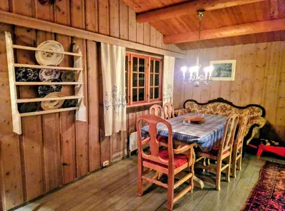 a wooden dining room with a table and chairs at Trivelig og romslig hytte nær Røros, rikelig med uteplass in Glåmos