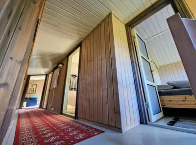a room with wooden walls and a red rug at Trivelig og romslig hytte nær Røros, rikelig med uteplass in Glåmos
