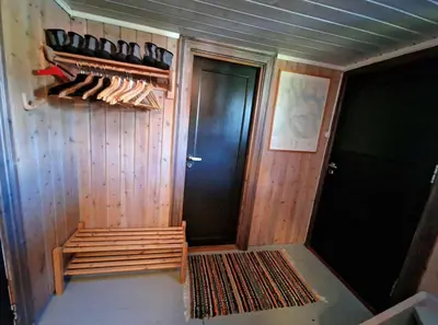 a room with a closet with wooden walls and a door at Trivelig og romslig hytte nær Røros, rikelig med uteplass in Glåmos