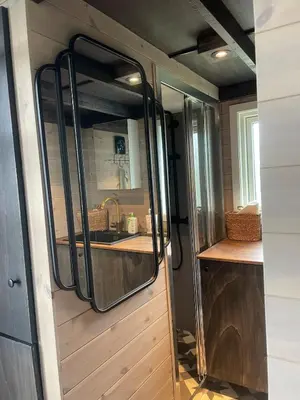 a kitchen in a tiny house with a mirror at Tiny house on wheels with great views Sjusjøen in Mesnali