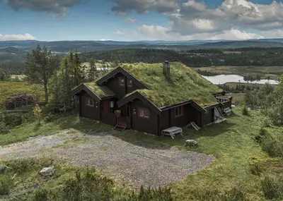 a house with a grass roof on a hill at Timber Cabin With Panoramic Views At Spåtind in Etnedal