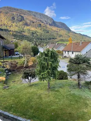 a small village with trees and a mountain in the background at Ski slopes nearby - Parking & WiFi in Vossevangen