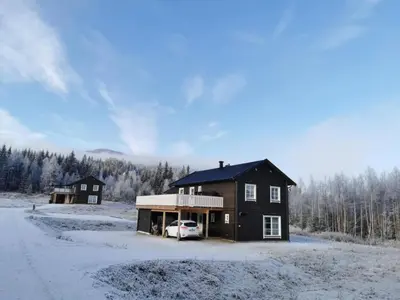 a house with a car parked in the snow at Trysil Central Villa in Trysil