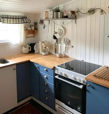 a kitchen with blue cabinets and a stove top oven at Family Cabin Near Rallarvegen And Geilo in Ustaoset
