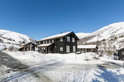 a large wooden house in the snow with mountains at Stranda Fjellgrend 3 bedrooms - 68B in Stranda
