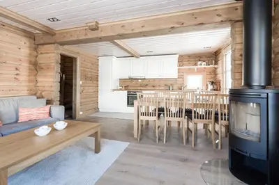 a living room with a table and a stove at Stranda Fjellgrend 3 bedrooms - 68A in Stranda