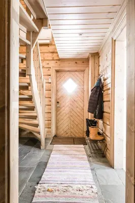 a hallway with a wooden door and stairs at Stranda Fjellgrend 3 bedrooms - 68A in Stranda