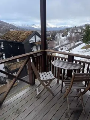 a table and chairs on a wooden deck with a view at Stranda Fjellgrend 3 bedrooms - 29C in Stranda
