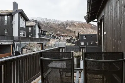 a balcony with two chairs and a table on a building at Stranda Fjellgrend 3 bedrooms and loft - 80C in Stranda