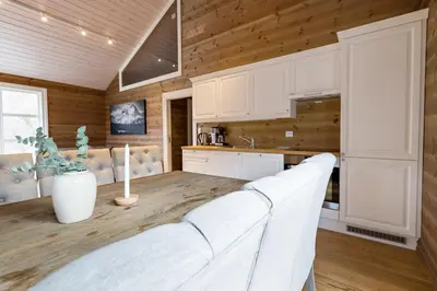 a kitchen with white cabinets and a white couch at Stranda Fjellgrend 3 bedrooms and loft - 80C in Stranda