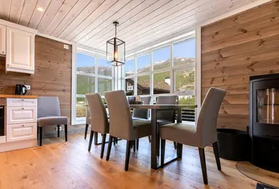 a dining room with a table and chairs and a fireplace at Stranda Fjellgrend 3 bedrooms - 32A in Stranda