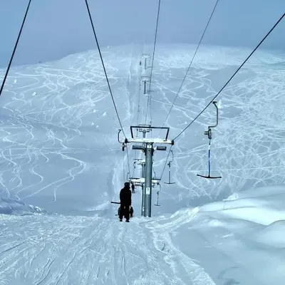 a person standing on a ski lift in the snow at Luster Lodge in Luster