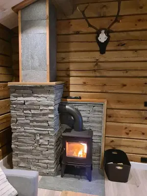 a wood stove in a room with a wall at Luster Lodge in Luster