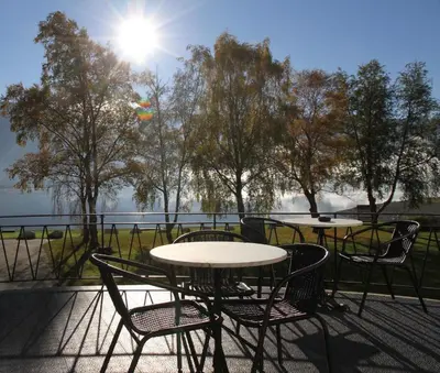 two tables and chairs on a patio with a view of the water at Park Hotel Vossevangen in Vossevangen