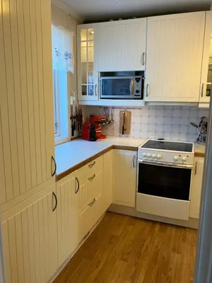 a kitchen with white cabinets and a stove top oven at Holiday home in Espevær in Bømlo