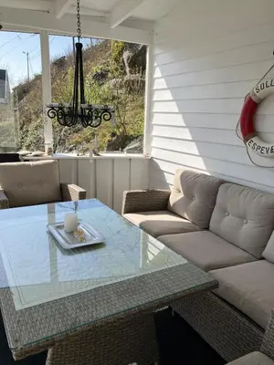 a living room with a couch and a glass table at Holiday home in Espevær in Bømlo