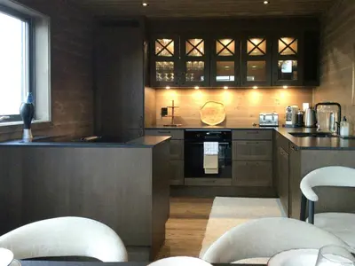 a kitchen with a counter and chairs in it at Warm And Inviting Cabin Near Norefjell in Eggedal