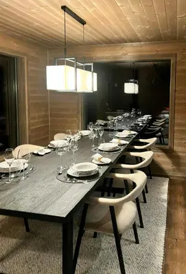 a long table with white plates and wine glasses at Warm And Inviting Cabin Near Norefjell in Eggedal