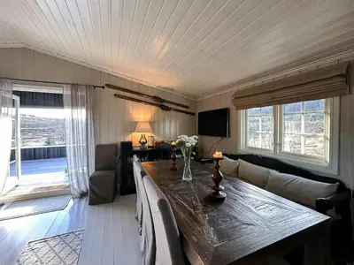 a living room with a table and a couch at Mountain Cabin With Magical Views At Dagalifjell in Uvdal