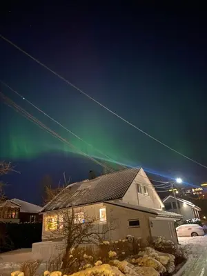 a house with the green northern lights in the sky at Art Nouveau in the middle of downtown Ålesund in Ålesund