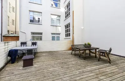 a patio with a table and benches on a building at Bright and modern city center apartment in Ålesund